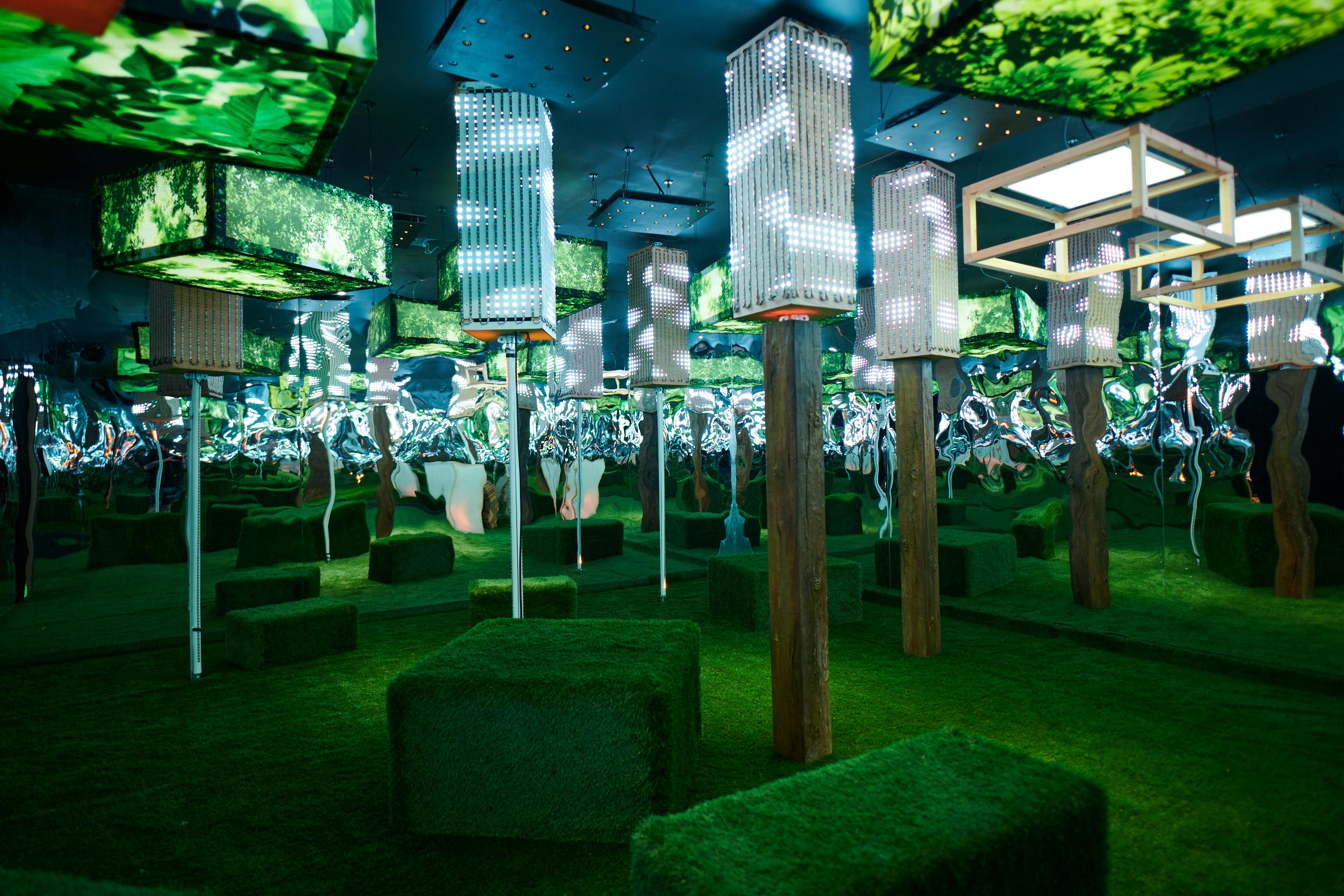 Artificial turf floor in a room with columns and light boxes as part of an art exhibition at Uptown Brisbane